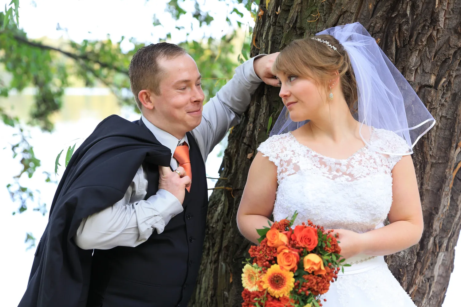Brautpaar mit schelmischem Blickkontakt im Herbst